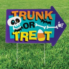 a sign that says trunk or treat on it in the grass with a skull and crossbone