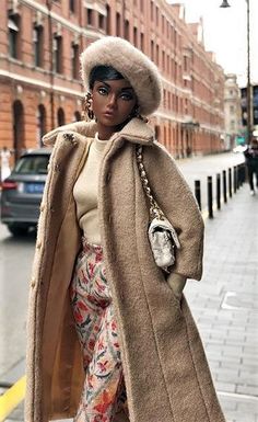 a woman is walking down the street wearing a coat and floral pants with a fur hat