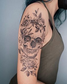 a woman with a skull and roses tattoo on her arm