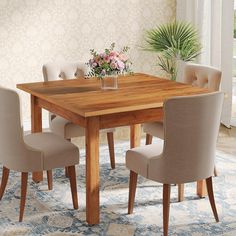 a wooden table with chairs around it and a vase on the table next to it