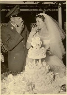 an old black and white photo of a bride and groom feeding each other cake