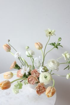 an arrangement of flowers on a marble table