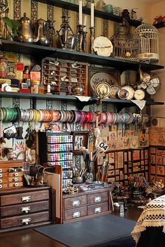 a room filled with lots of assorted items on shelves next to a dresser and table