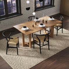 a dining room table with chairs and plates on the table in front of two windows