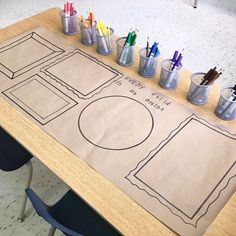 a table with markers and pencils on it in front of a cardboard cutout