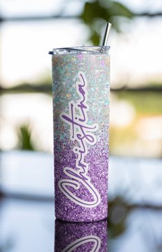 a purple and white glitter tumbler with a straw sticking out of it's lid