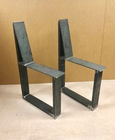 two metal chairs sitting next to each other on a table