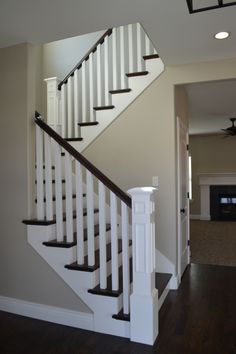 an empty living room with stairs leading up to the second floor