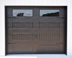 a brown garage door with two windows