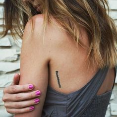 a woman with pink nail polish holding her arm up to her chest and looking at the camera