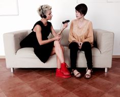 two women sitting on a couch talking to each other