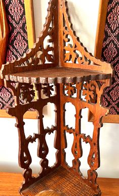 an ornate wooden shelf on top of a table