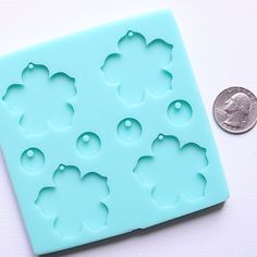 "Handmade silicone mold. Makes 4 flower shape drop pendants with four 1/2\" in diameter coin shape drops that are great to make for dangle earrings or pendant necklaces. Each flower is approx. 1 ½ in diamter x ⅛\" deep. PLEASE NOTE: Do not use a torch--it will damage the mold. The best way to remove dust, lint, glitter, etc is to use a piece of tape to gently lift debris. Please inspect the mold before use. Quarter in photo(s) for size reference. LISTING IS FOR MOLD ONLY. OUR SILICONE IS NOT FOO Floral Resin, Flower Earring, Wedding Gifts For Guests, Photo S, Drop Earring, Resin Molds, Drop Pendant, Flower Charm, Flower Pendant