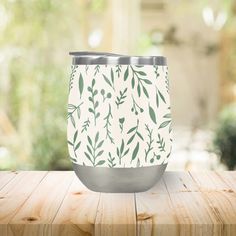 a white and green cup sitting on top of a wooden table