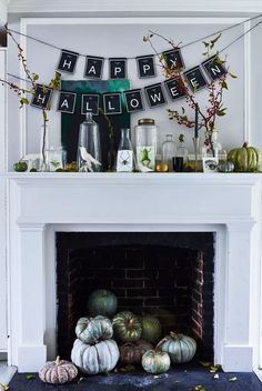 a fireplace decorated for halloween with pumpkins, candles and decorations on the mantel