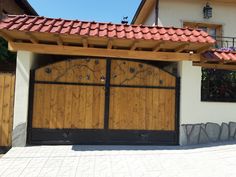 a house with two wooden garage doors on the outside and bricked roof above it