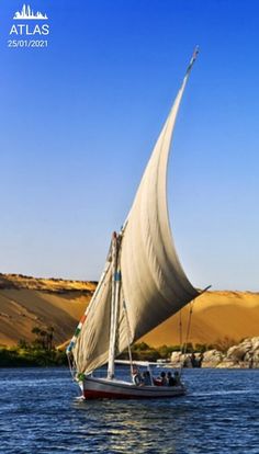 a sailboat sailing on the water near sand dunes