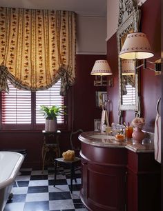 a bathroom with a checkered floor and red walls, along with a white bathtub