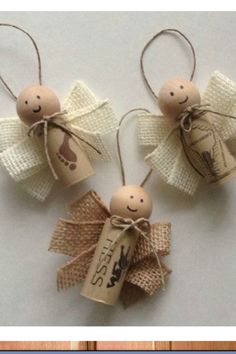 two wooden angel ornaments with tags attached to them