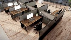 an office cubicle with two desks and one computer on the other side, in front of a glass wall