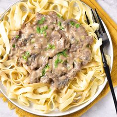 a white plate topped with pasta covered in gravy