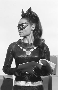 a woman dressed as catwoman reading a book