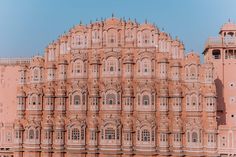 a large pink building with many windows on it