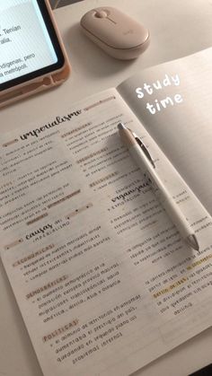 an open book on a table next to a computer mouse and cell phone with the text study time written in it