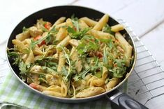 a pan filled with pasta and vegetables on top of a table