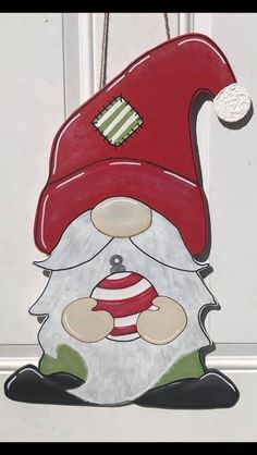 a christmas ornament hanging on the door with a santa clause hat and beard