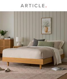 a bed sitting on top of a wooden floor next to a dresser and lamp in a bedroom