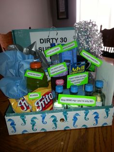 a box filled with lots of different items on top of a wooden table next to a chair