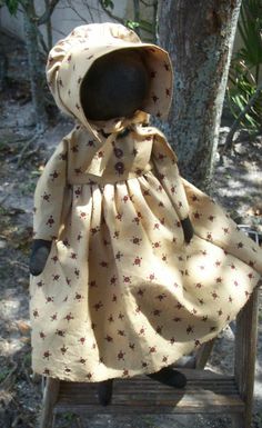 a doll sitting on top of a wooden chair