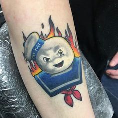 a person with a tattoo on their arm that has a book and fire coming out of it