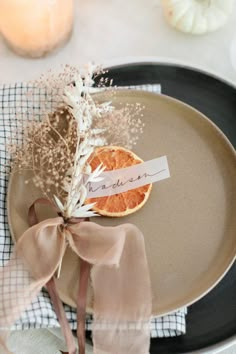 a plate with an orange on it and a ribbon tied around the edge