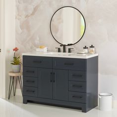 a bathroom vanity with a round mirror above it