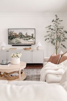 a living room filled with furniture and a painting on the wall above it's coffee table