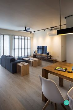 a living room filled with furniture and a flat screen tv on top of a wooden table