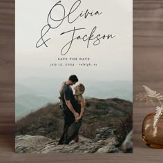 an image of a couple kissing on top of a mountain