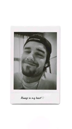 a black and white photo of a man with his head tilted to the side smiling