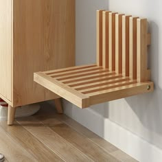 a wooden bed sitting on top of a hard wood floor next to a white wall