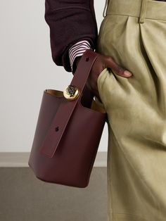 Loewe's 'Pebble' tote debuted on the Spring '24 runway. Crafted from burgundy leather, it has a structured base and a wide top handle that can be adjusted using the glossy 'Anagram' clasp. It's sized to hold just the essentials, like your cardholder, makeup compact and phone. Bucket Bags Outfit, Winter Dressing, Makeup Compact, Loewe Bag, Denim Trends, Leather Trench Coat, Leather Bucket Bag, Leather Bucket, Knitting Accessories