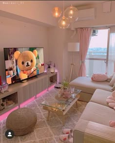 a living room filled with furniture and a large teddy bear on the tv