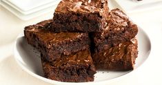 some brownies on a white plate with chocolate frosting