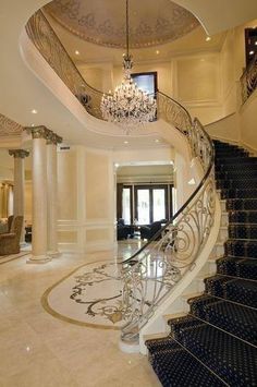 an elegant staircase with chandelier and marble floors