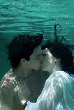 two people are kissing under the water