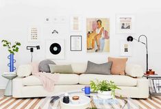 a living room filled with lots of furniture and pictures on the wall above it's coffee table