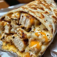 a burrito with chicken and cheese on it