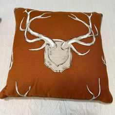 a brown pillow with white deer's head on it