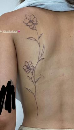 a woman with a flower tattoo on her back